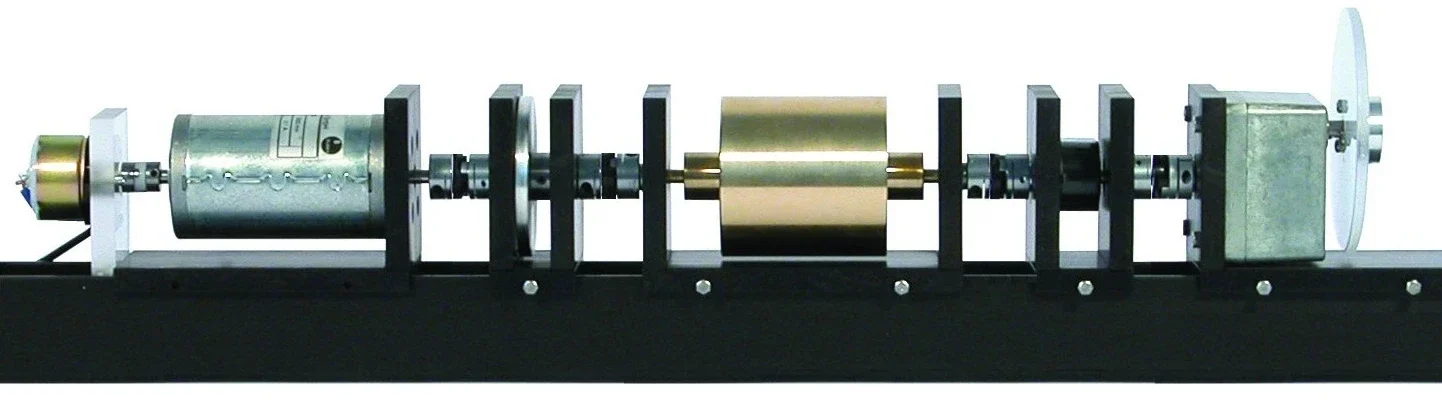 Foto des Servomotor-Prüfstands: Gleichstrommotor, magnetische Bremse, rotierende Messingmasse und Encoder auf einer gemeinsamen Welle.